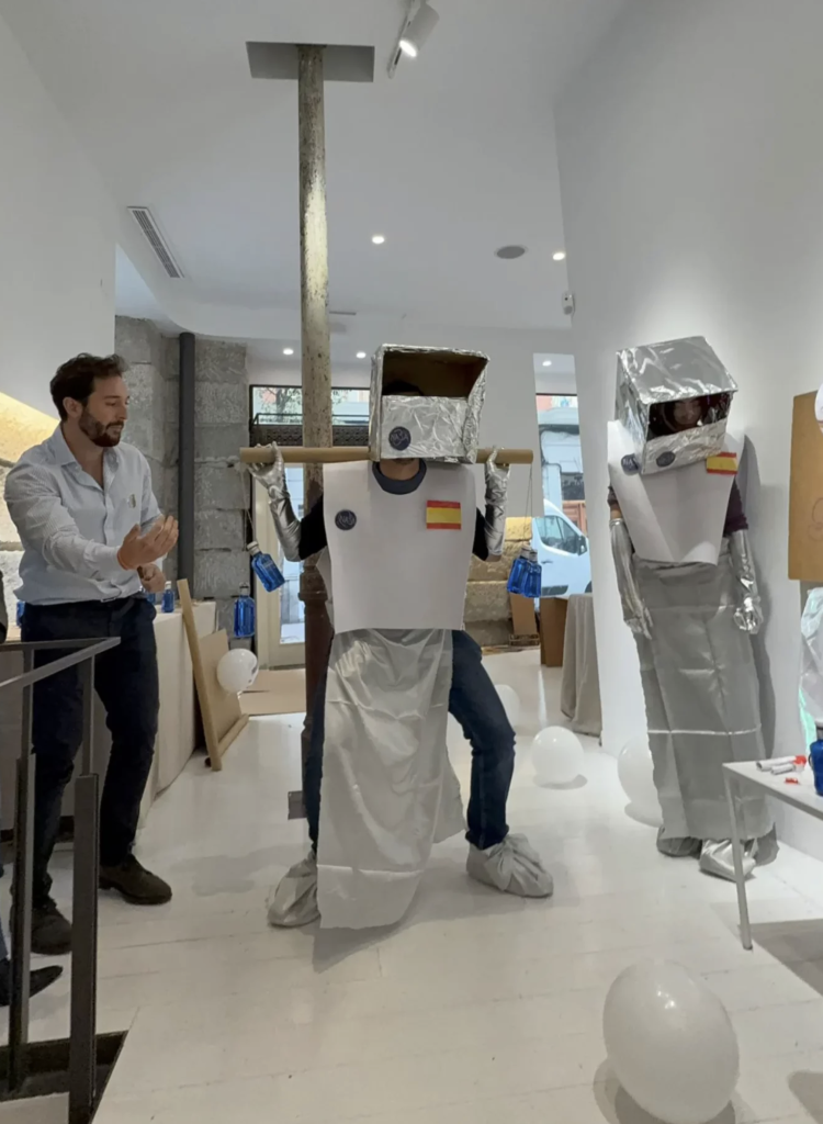 Participantes representando una dinámica creativa con disfraces durante un taller de equipo.