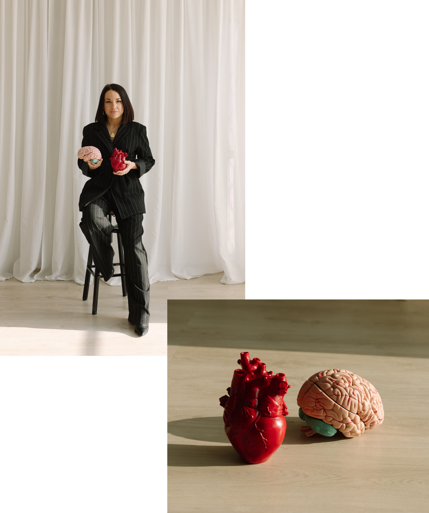 Gladys Kali sosteniendo un modelo anatómico del cerebro y un corazón anatómico.